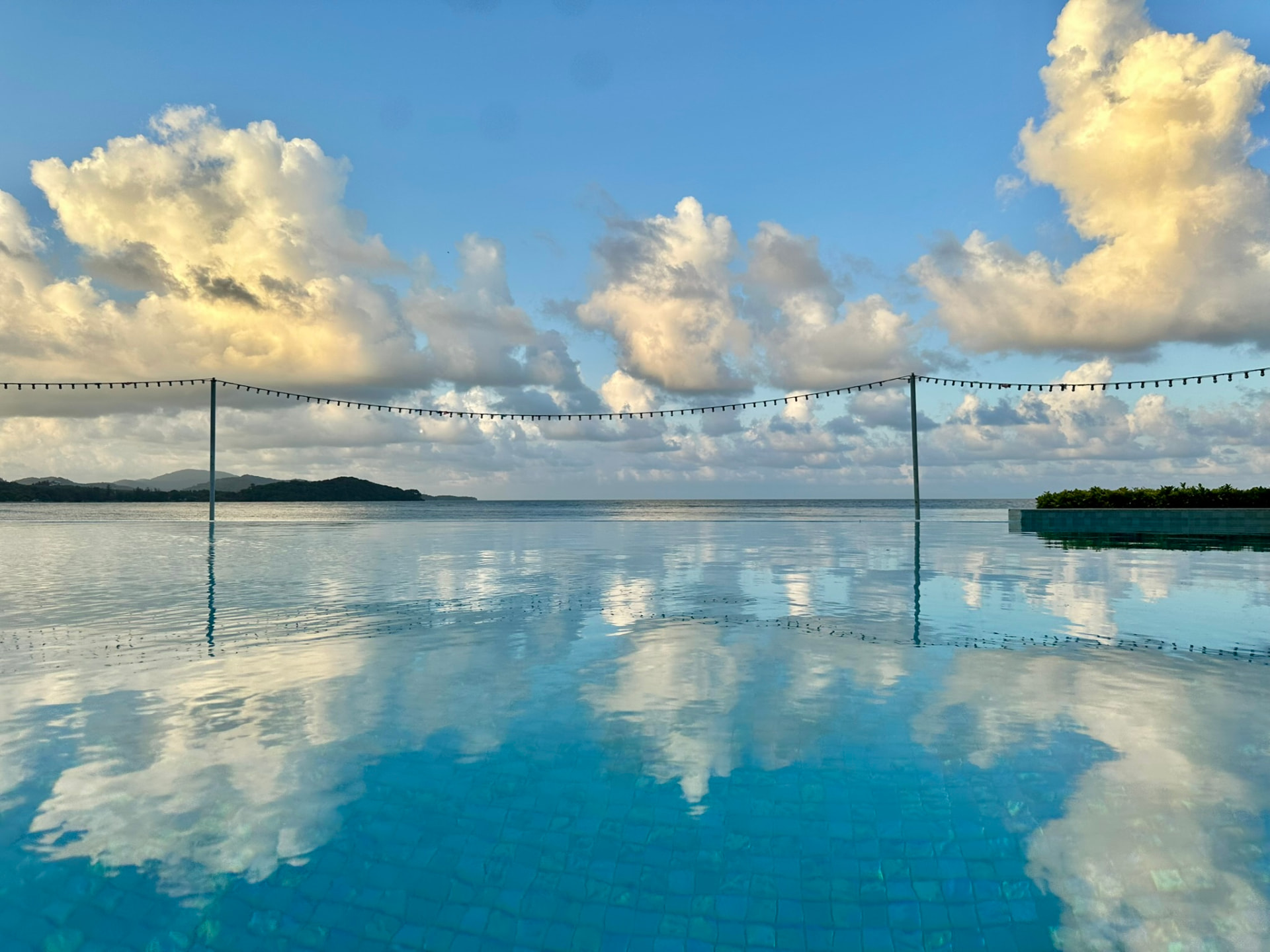 Clouds reflected in the still infinity pool at first light