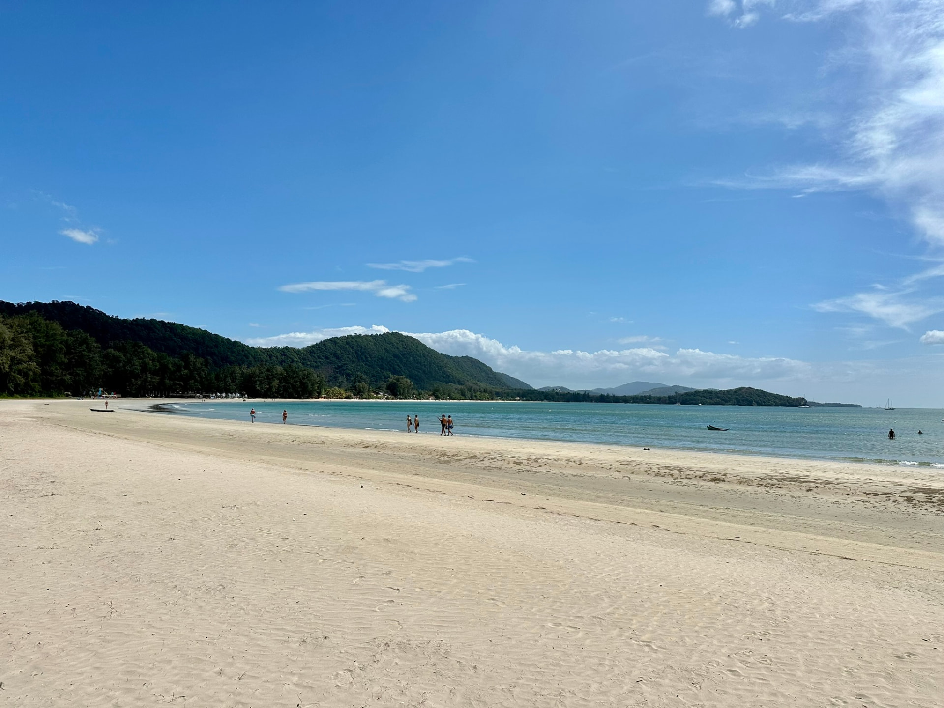 Wide white sand beach curving toward the headland on Koh Lanta